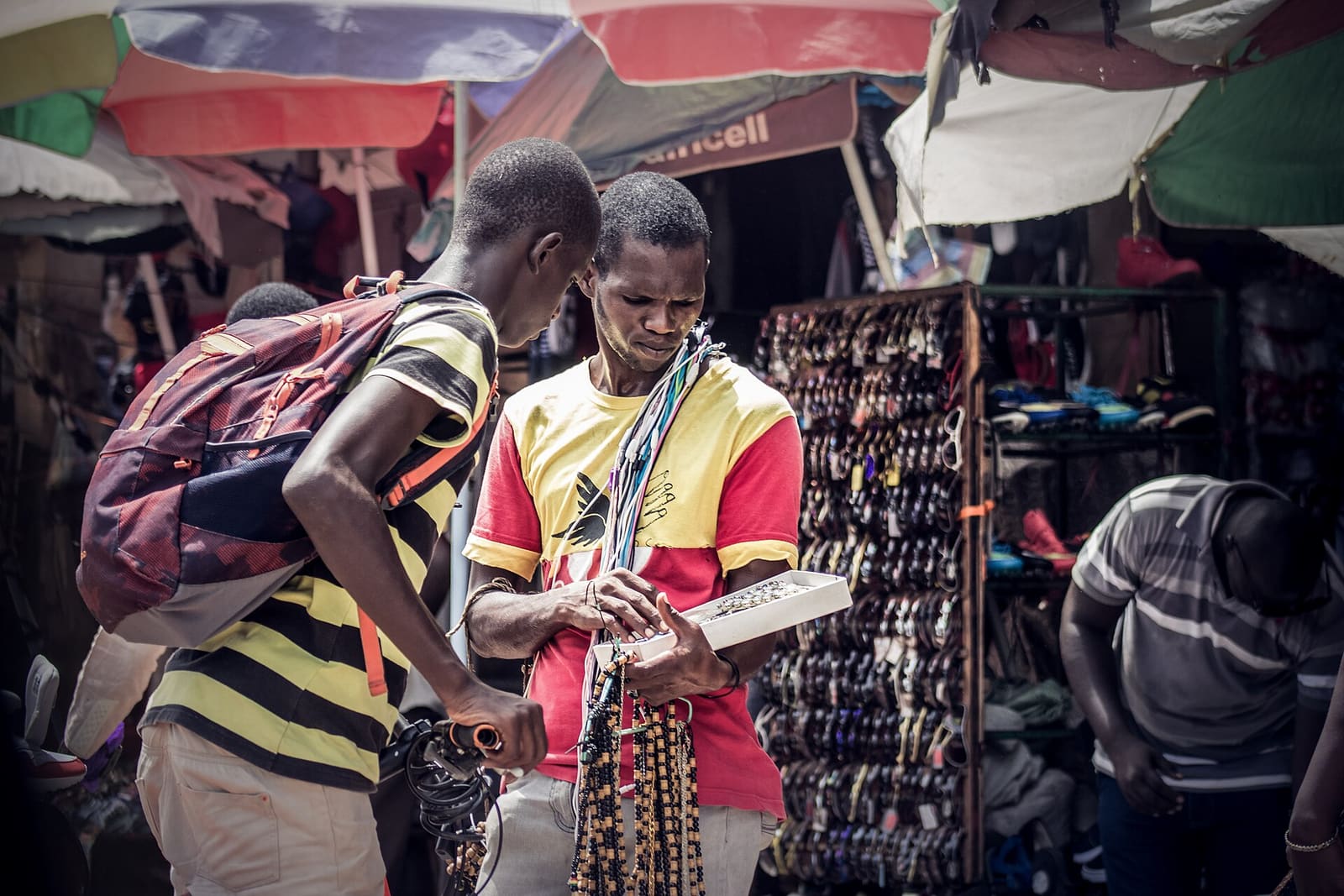 A seller and buyer exchanging goods in Serekunda market, The Gambia